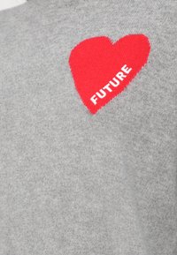 Szürke kötött pulóver, amelyen egy kiemelkedő piros szív motívum található, a "FUTURE" szó fehér szöveggel. Puha tapintású, laza stílusú.
