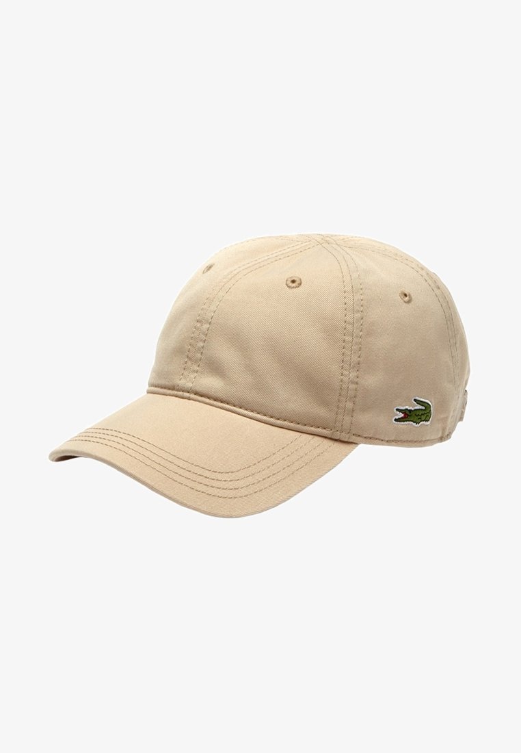 Casquette de baseball beige en coton avec panneaux cousus, œillets de ventilation, visière courbée et petit logo crocodile vert sur le côté.