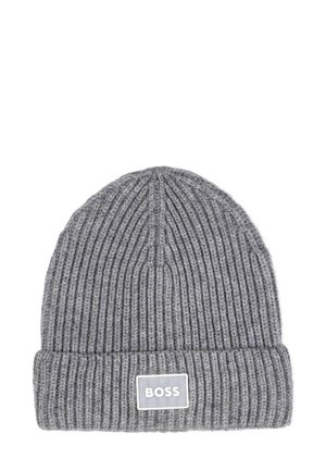 Bonnet en tricot gris avec une texture côtelée, doté un revers et d'une étiquette rectangulaire blanche portant le logo "BOSS".