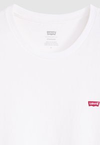 Witte katoenen t-shirt met een ronde halslijn en een klein rood geborduurd Levi's-logo op de linkerkant van de borst. Standaard pasvorm, gladde textuur.
