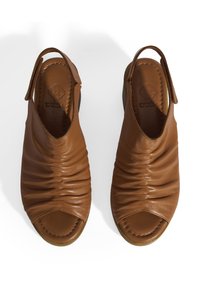 Braune Leder-Sandalen mit offener Zehenpartie, gerafftem Design, Slingback-Optik und weitem, abgerundeten Absatz. Logo in die Innensohle eingeprägt.