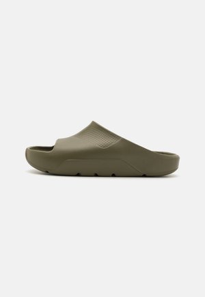 Olive green slide sandal, made from plastic. Features a textured upper with perforations, a thick sole, and a slightly raised heel.