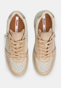 Bežid sneakersid, millel on nahk ülemine osa perforatsiooni disainiga, tekstuuriga varbakatte osa, kontrastsete värvide aktsendid, nöörid ja külgketid.
