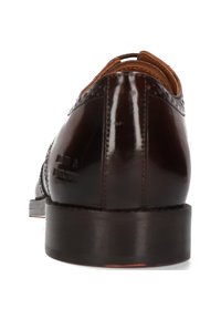 Scarpa in pelle marrone con una finitura lucida, dotata di punta rotonda, perforazioni decorative e un tacco basso impilato. Dettaglio di branding discreto visibile.