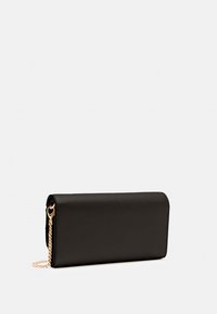 Portafoglio in pelle nera con finitura texture, forma rettangolare slim e un accento in catena dorata attaccata a un anello laterale.