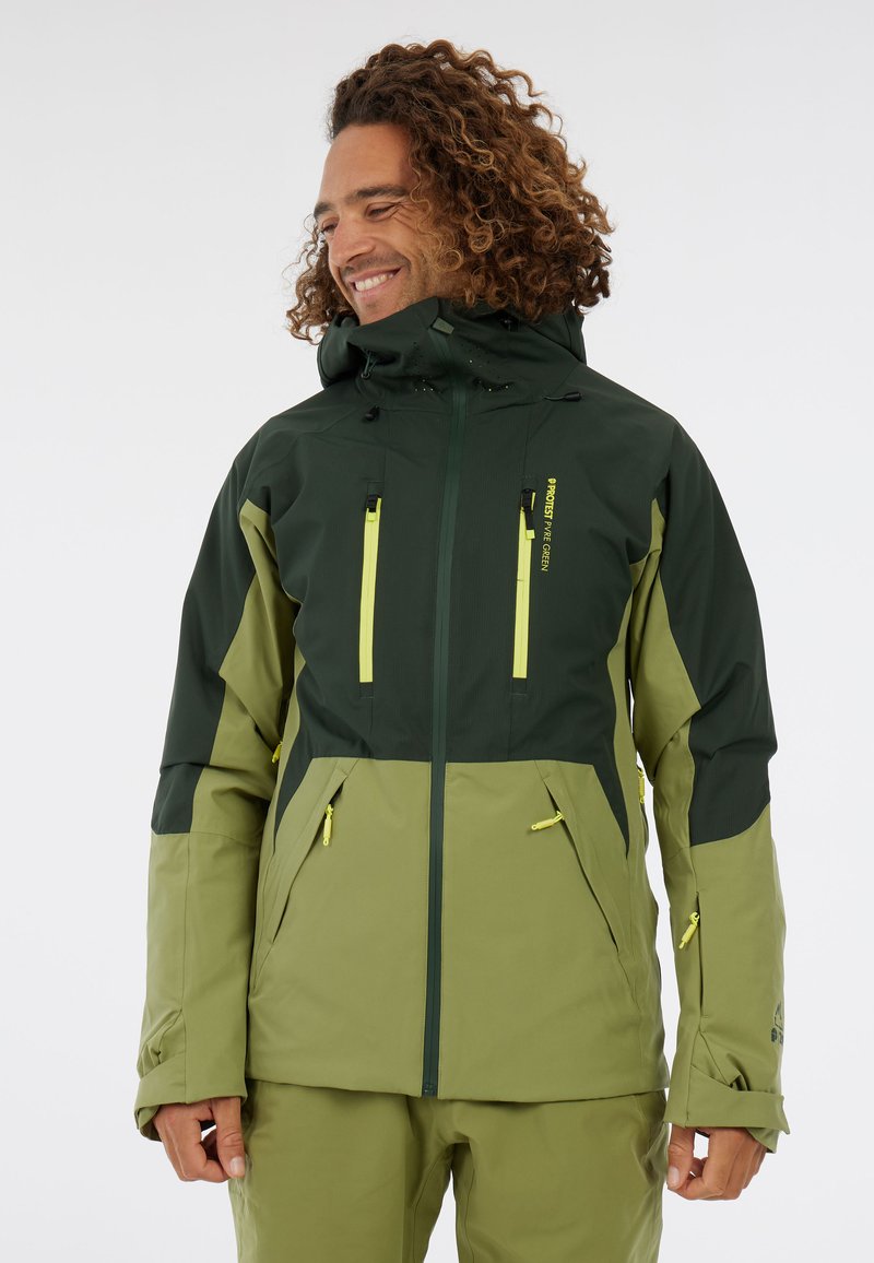 Vetruodolná bunda v tmavozelenej a svetloolivovej farbe, s vreckami na zips, nastaviteľnými manžetami a odnímateľnou kapucňou. Hladká textúra a elegantný dizajn.