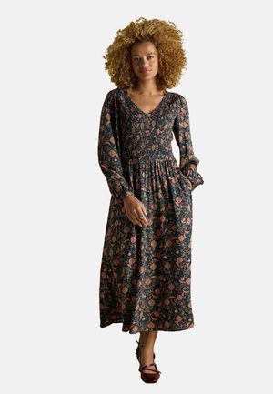Langes Blumenkleid mit V-Ausschnitt, langen Ärmeln und elastischem Bund. Der Stoff hat einen dunklen Hintergrund mit bunten Blumenmustern.