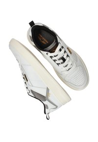 Baskets basses blanches avec des accents en maille noire et grise, lacets blancs, semelle rembourrée et logo PME Legend sur la languette et l'étiquette latérale.