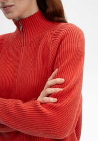 Geribbelde gebreide, rits-sweater in levendig koraalrood. Heeft een hoge kraag en een relaxte pasvorm, die een textuurpatroon en zachte stof laat zien.