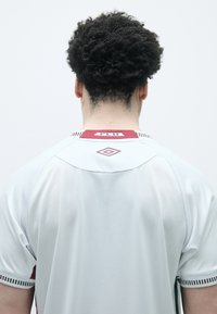 Camisola atlética branca com colarinho bordeaux, apresentando um acabamento listrado em vermelho, verde e branco e uma etiqueta de logotipo na nuca.