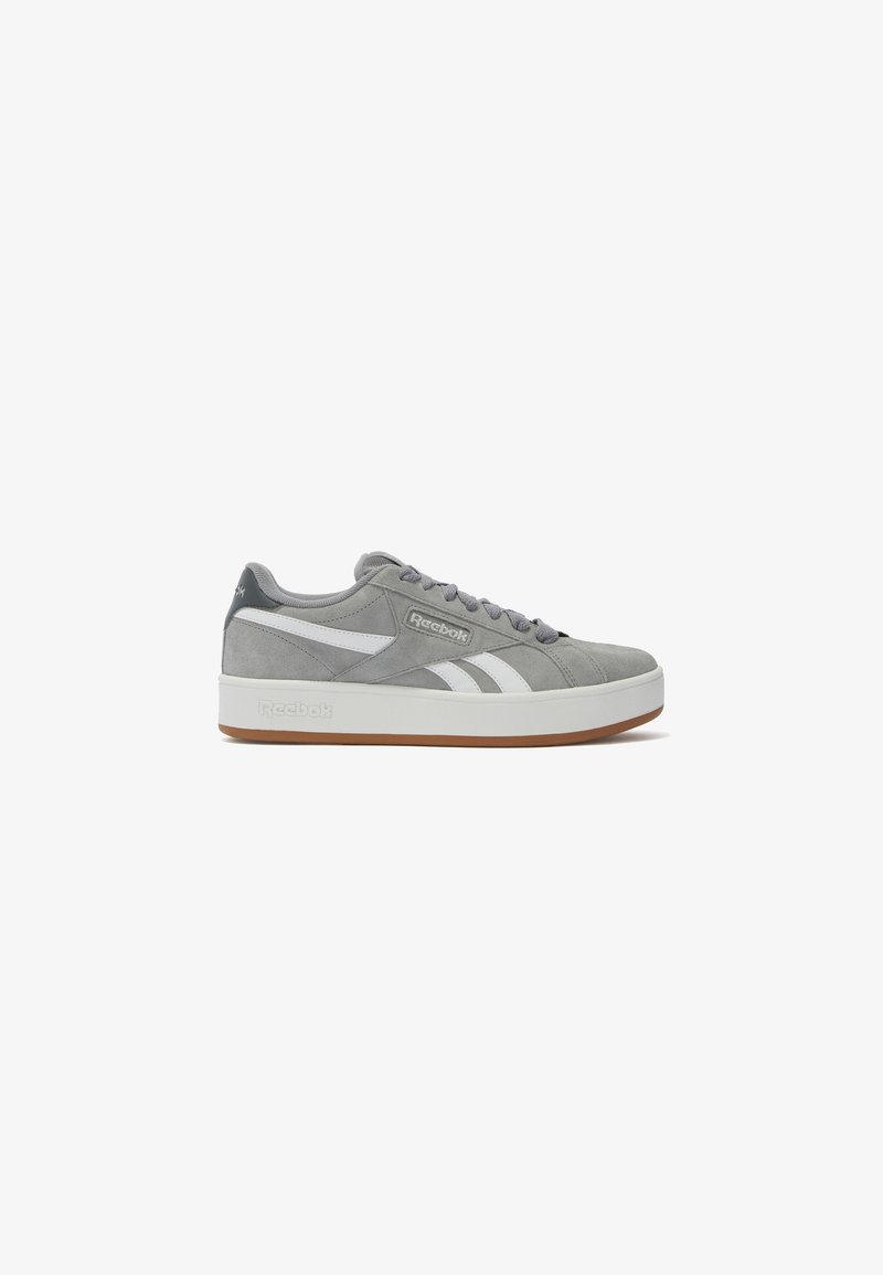 Baskets Reebok en daim gris avec des bandes blanches sur les côtés, lacets gris, semelle blanche et semelle extérieure marron, vues du côté extérieur.