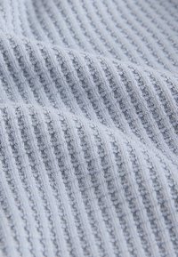Tessuto lavorato a maglia azzurro chiaro con coste testurizzate e piccoli motivi orizzontali, che mette in mostra un materiale morbido ed elastico con una finitura liscia.