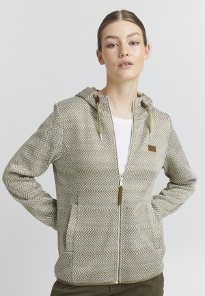 Giacca con cappuccio e zip realizzata in tessuto a fantasia beige e crema, con due tasche frontali e dettagli con lacci.