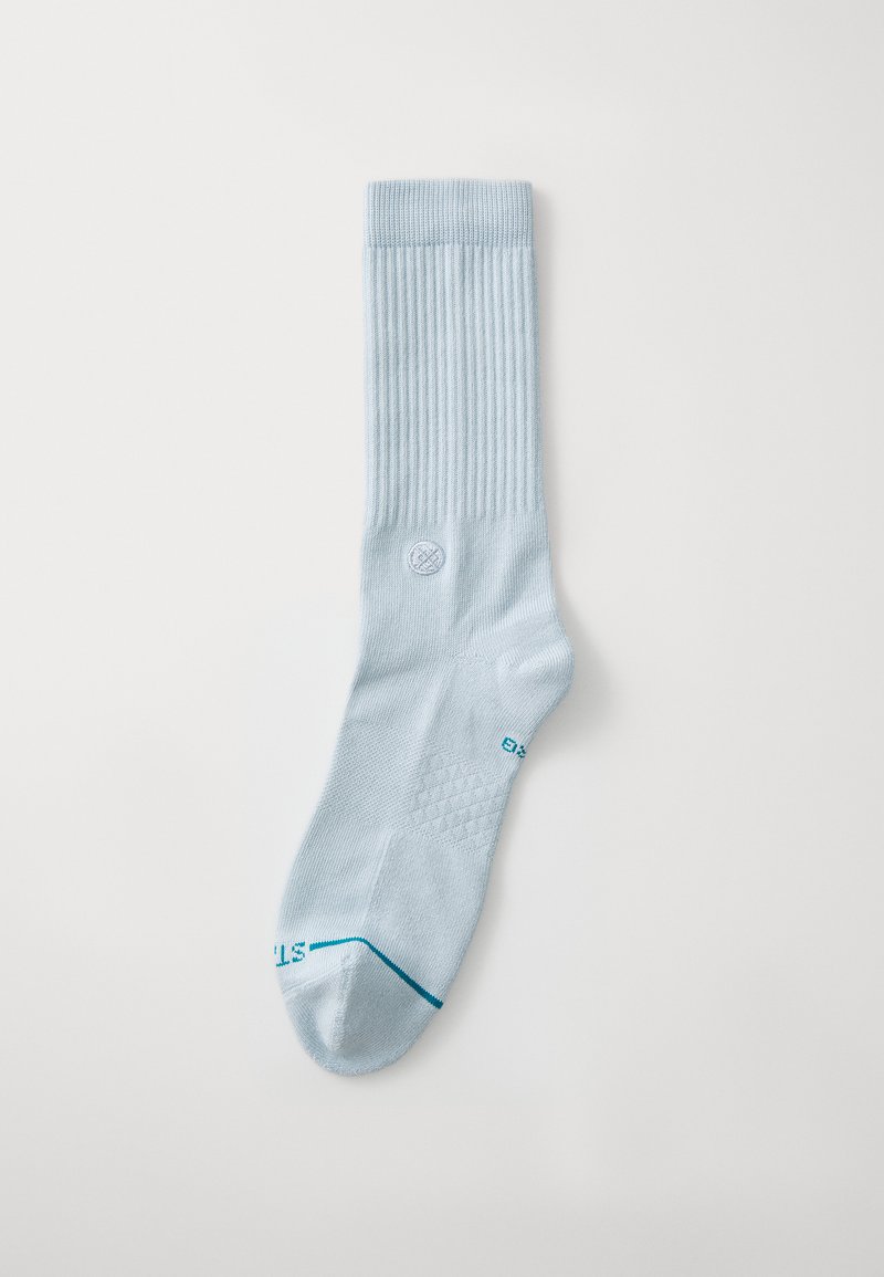 Calcetín de rodilla azul claro con textura acanalada, puntera y talón reforzados, y detalle del logo cerca del puño, con un acabado suave.