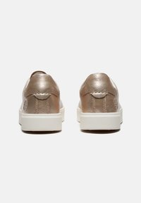 Metallic rose gold sneakers with a smooth leather finish, white rubber soles, and stitched detailing at the heel. Minimalistic design.