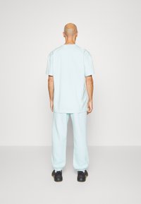 adidas Performance ESSENTIALS FEELVIVID FLEECE STRAIGHT - Jogginghose - blue