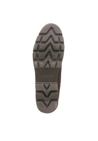 Shoe sole featuring a rugged, patterned design with deep treads for traction, predominantly dark grey with a solid, sturdy structure.