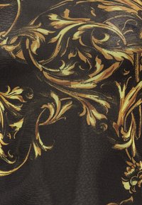 Svart tyg med utsmyckade gyllene-gula barockblommor och virvlande mönster som bildar intrikata dekorativa motiv.