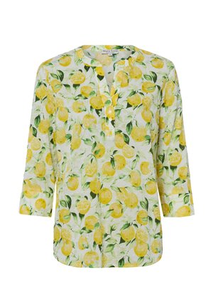 Blouse blanche avec imprimé citrons jaunes et feuilles vertes, encolure ronde, manches trois-quarts et patte de boutonnage sur le devant.