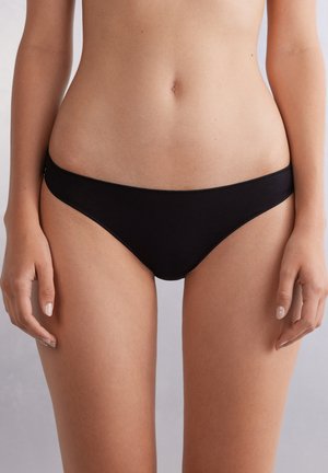 Zwarte katoenen bikini slipjes met een low-rise snit, voorzien van een gladde textuur en minimale stiksels. Ontworpen voor comfort en een naadloze pasvorm.