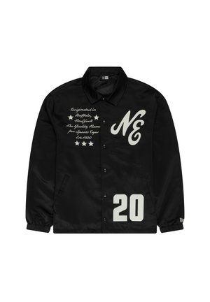 Veste en nylon noire avec boutons-pression, texte imprimé blanc et un grand "20" sur le devant. Elle possède des poches latérales et un col.