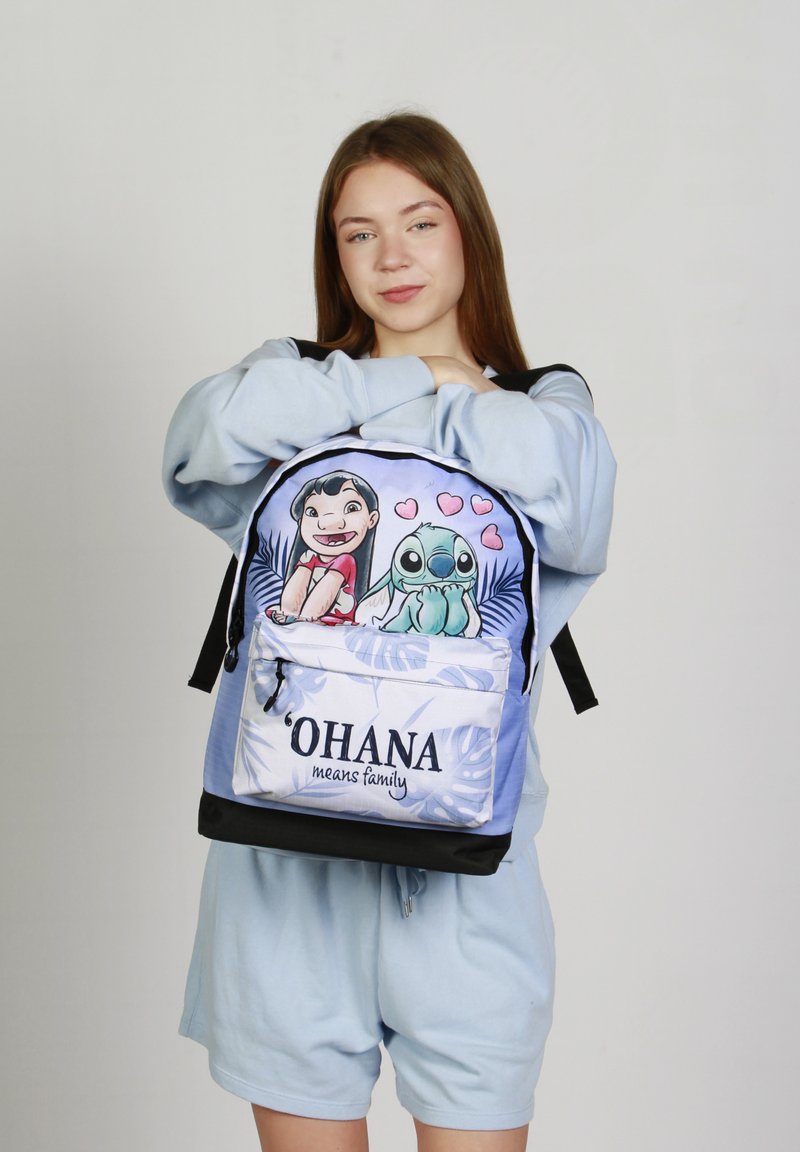 Mochila azul con personajes de dibujos animados, con un bolsillo frontal que muestra el texto "‘OHANA significa familia" y patrones decorativos de hojas tropicales.