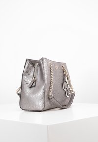 Metalen zilveren handtas met een gestructureerde vorm, featuring een geprofileerde oppervlakte, dubbele kettingband en een decoratieve vlinderhanger.