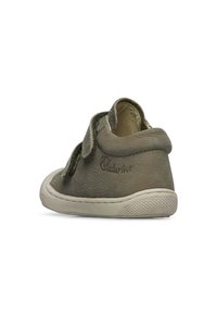 Chaussure en cuir vert avec une sangle Velcro, bout arrondi et tige texturée. Dispose d'une semelle en caoutchouc et d'un logo de marque embossé sur le côté.