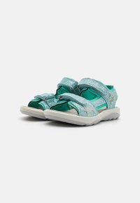 Turkise sandaler med en glitrende overdel, borrelåsremmer, åpen tå-design og polstret såle. Har en stjerneaccent på siden.