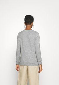 Grauer Langarm-Sweatshirt mit Rundhalsausschnitt und gerippten Bündchen, das eine weiche Textur und eine lockere Passform aufweist.