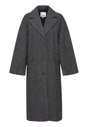 Houndstooth raksts melnbaltā mētelī, ar izgriezto apkakli, priekšējo pogu aizdari un sānu kabatām.
