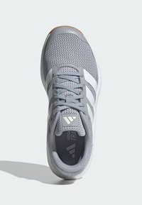 Szare buty sportowe z siateczkowej cholewki, białymi paskami, teksturowaną powierzchnią, wyściełanym kołnierzem i gumową podeszwą. Posiadają szczegóły logo na języku.