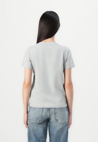 Grå bomulls t-skjorte med korte ermer, rund hals og en tettsittende design. Stoffet ser mykt ut med en lett tekstur.