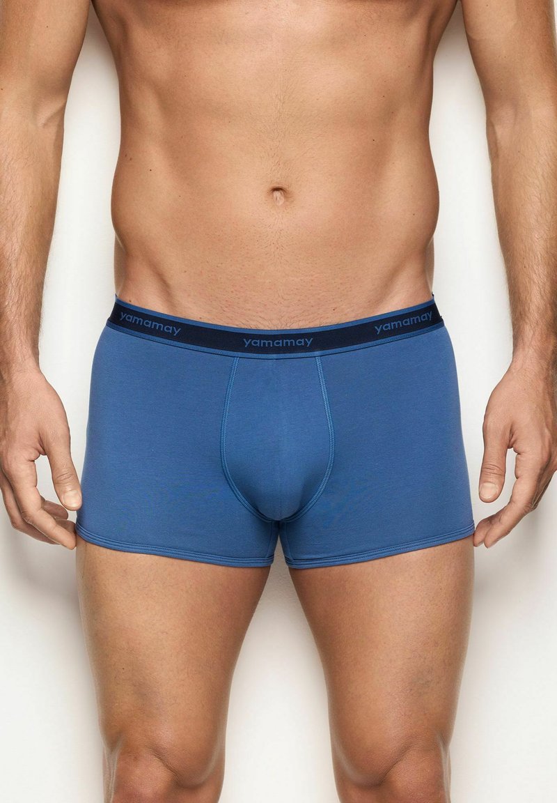 Boxer shorts de algodón azul con una textura suave, con una cinturilla elástica en color marino etiquetada "yamamay" y un diseño ajustado.