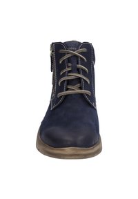 Bottines en cuir bleu marine avec un bout arrondi, dotées de lacets gris et d'une fermeture éclair sur le côté. La semelle est beige avec un fini texturé.