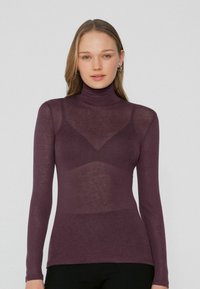 Dlouhý rukáv rolák v tmavě fialové barvě, vyrobený z průsvitné látky s upnutým střihem, s kontrastním trojúhelníkovým panelem.