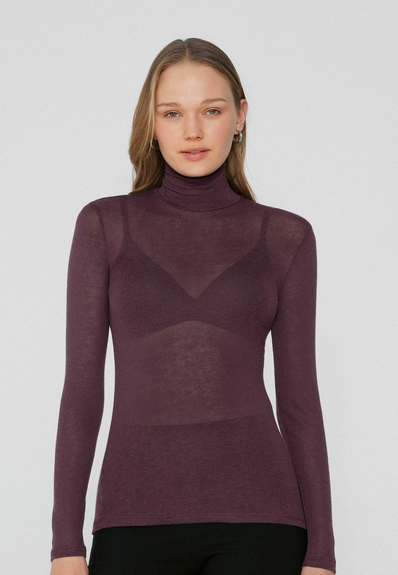 Dlouhý rukáv rolák v tmavě fialové barvě, vyrobený z průsvitné látky s upnutým střihem, s kontrastním trojúhelníkovým panelem.