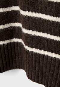 Brązowy sweter wykonany na drutach z białymi poziomymi paskami. Teksturowana tkanina z prążkowanym dołem, prezentująca miękki i przytulny wygląd.