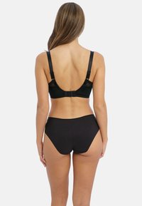 Conjunto de ropa interior negra que incluye un sujetador con espalda de encaje, tirantes ajustables y cierre por banda, combinado con bragas de cintura alta a juego.