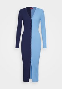 Robe à manches longues côtelée avec un décolleté en V profond, présentant une fente sur le côté. Côté gauche bleu marine foncé, côté droit bleu clair, avec une fermeture à boutons centrale.