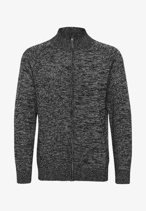 Sivobela in črna zip-up jopica z visokim ovratnikom, teksturirano pletenje in rebraste manšete ter rob. Ima celotno dolžino zadrge.