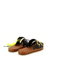 Zwarte en gele sandalen met een gestructureerde bruine zool, open teenontwerp en verstelbare banden voor een veilige pasvorm. Lichtgewicht materiaal.