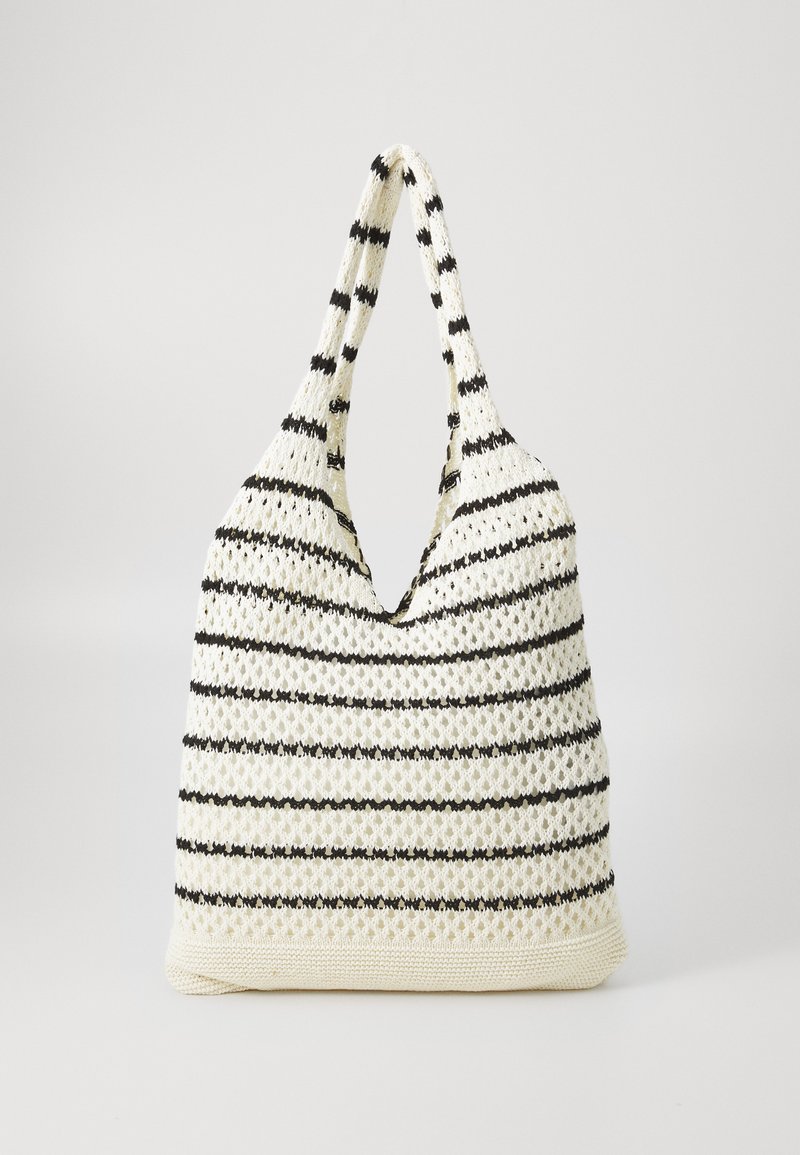 Knitted tote bag with a v-shaped opening, featuring a cream base and alternating black stripes. Soft texture and elongated handles.