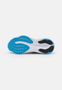 Suola di scarpe da corsa con un motivo di trazione in gomma blu, intersuola bianca e dettagli neri. Design testurizzato per aderenza e stabilità.