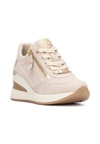 Zapatilla deportiva beige con un upper texturizado, acentos dorados, cierre de cordones y una cremallera lateral. Presenta un tacón cuña acolchado.