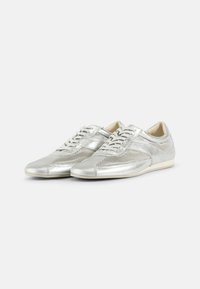 Sølvnetting joggesko med en glatt metallisk finish, som har snøring, subtile detaljer og en rund tåform.