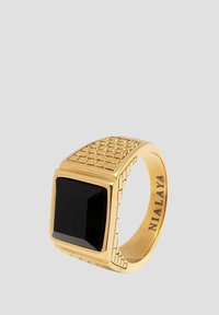 Guld ring med en firkantet sort sten, teksturerede detaljer på delen, og en glat inderside med "NIALAYA" indgraveret.