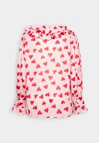 Blouse rose à manches longues avec motif de cœurs rouges, col à volants et poignets boutonnés.