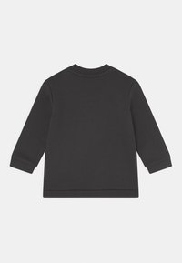 Sweatshirt preto com mangas longas, punhos canelados e decote redondo. Textura suave e corte descontraído, sem logótipos ou padrões visíveis.