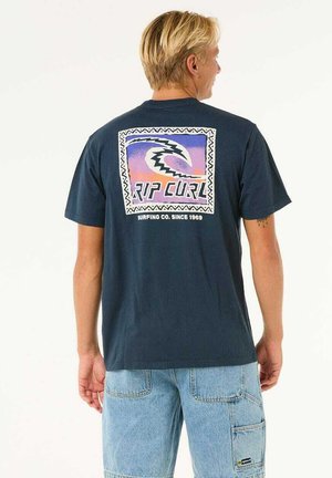 Navy blue cotton t-shirt featuring a colorful retro graphic on the back with the text "RIP CURL" surrounded by a zigzag border.